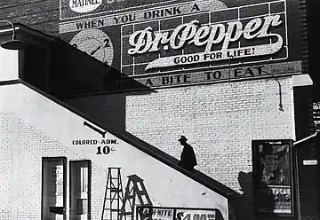 A black man going into a segregated movie theater through the "colored" entrance (Mississippi, 1939)