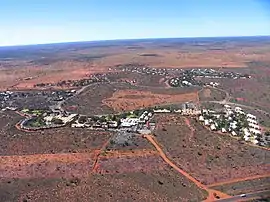 Aerial view of a small town surrounded by flat, red plains