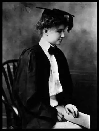 Keller seated in a mortar board and formal attire