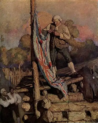 A man in a formal wig and suit, standing on the roof of a log cabin, hoists the Union Flag.