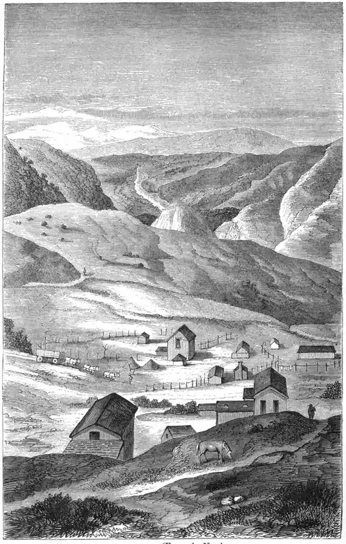 Engraving of a small collection of hillside buildings with mountains in the background