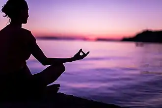 Individual practising meditation, a common positive psychology intervention.