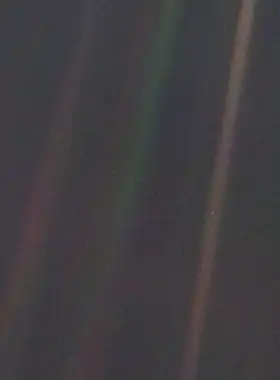 Dark grey and black static with coloured vertical rainbow beams over part of the image. A small pale blue point of light is barely visible.