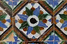 A tile with an ornate, colorful radial pattern