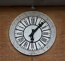 a large clock on a brick wall