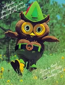 Photograph of an owl mascot costume in a woodland setting.