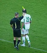 A referee giving a yellow card.